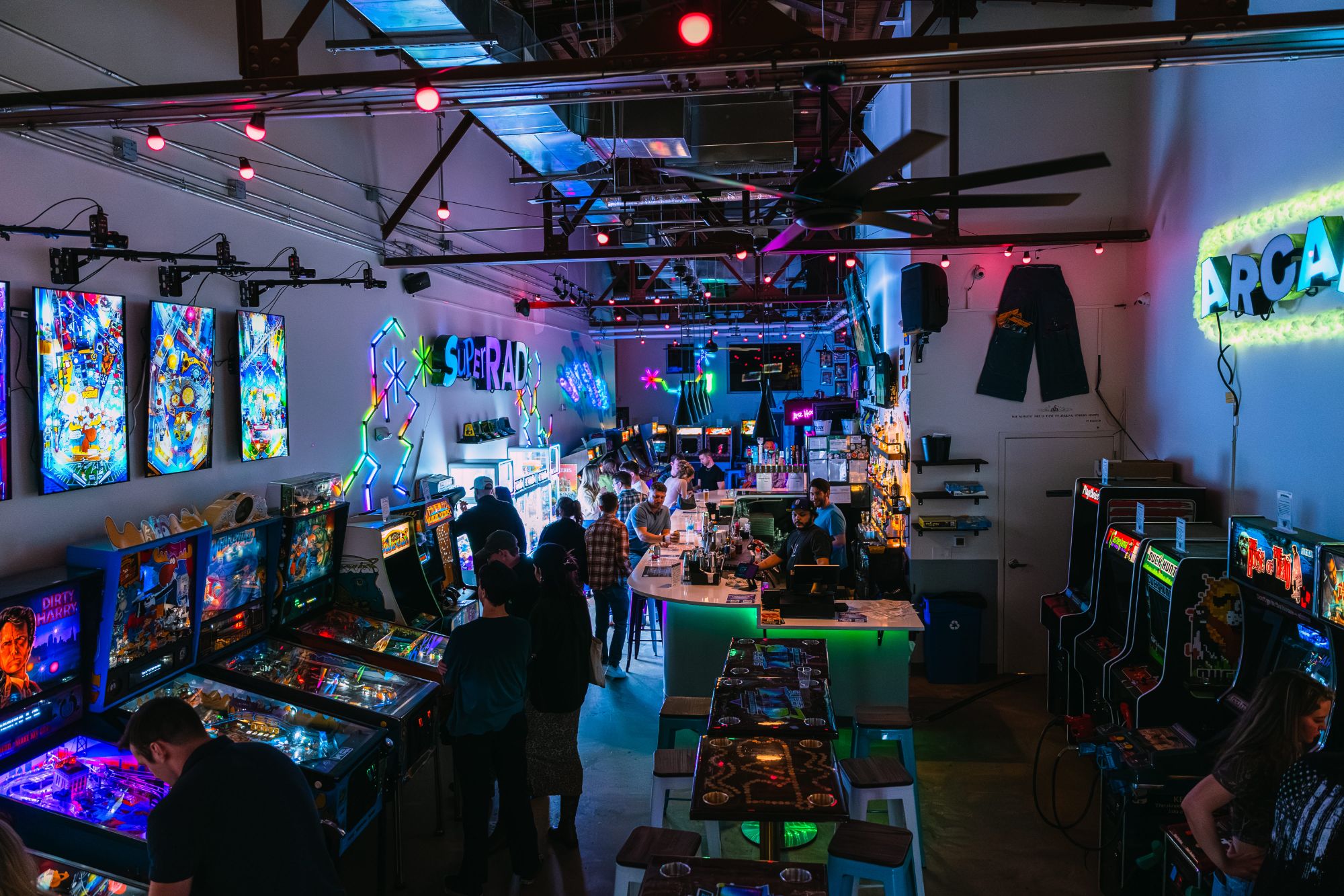 Classic arcade games glowing in the neon-lit room at Super Rad Retro Lounge