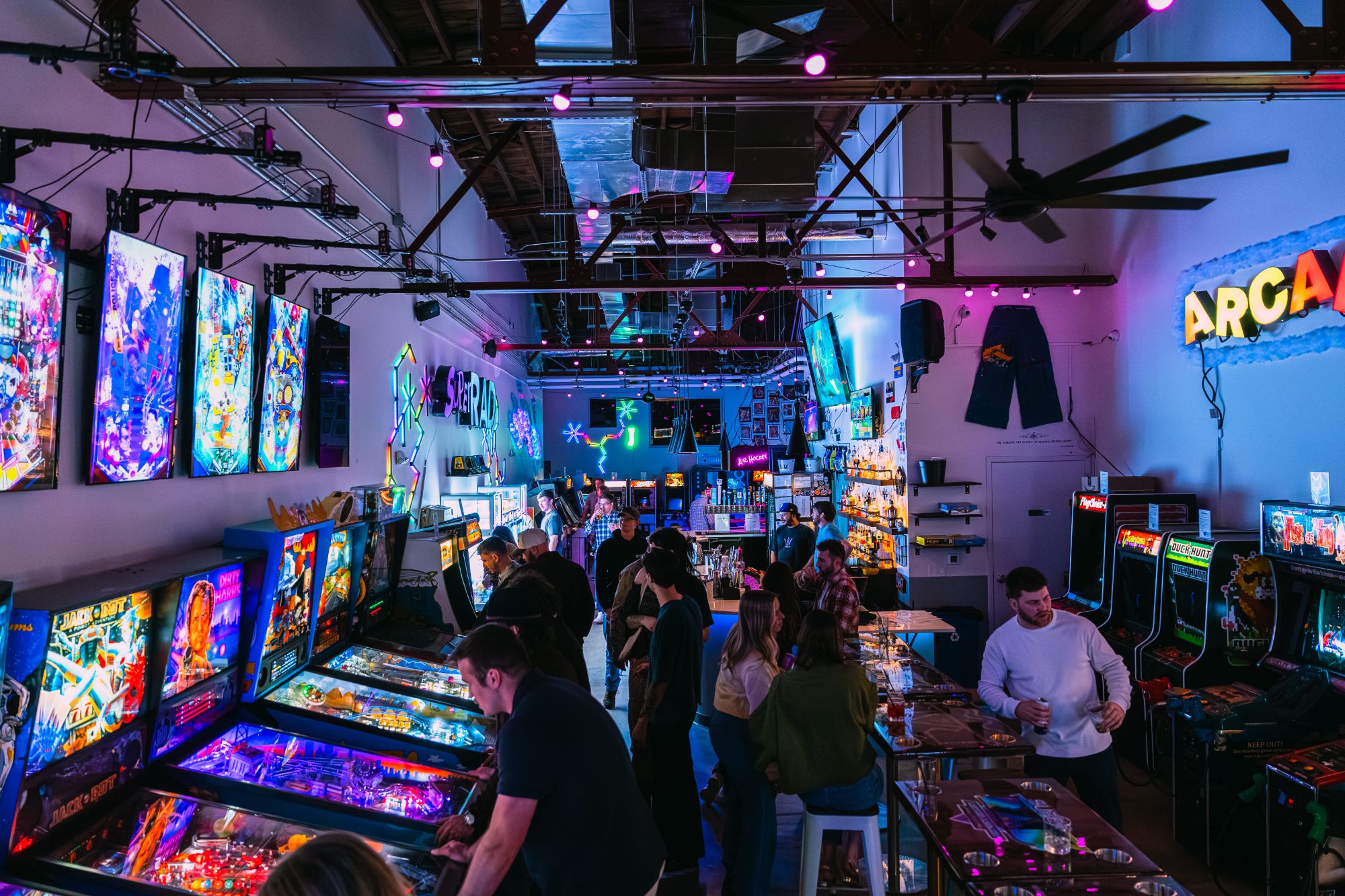 A crowd of guests playing games at a group celebration at Super Rad Raleigh