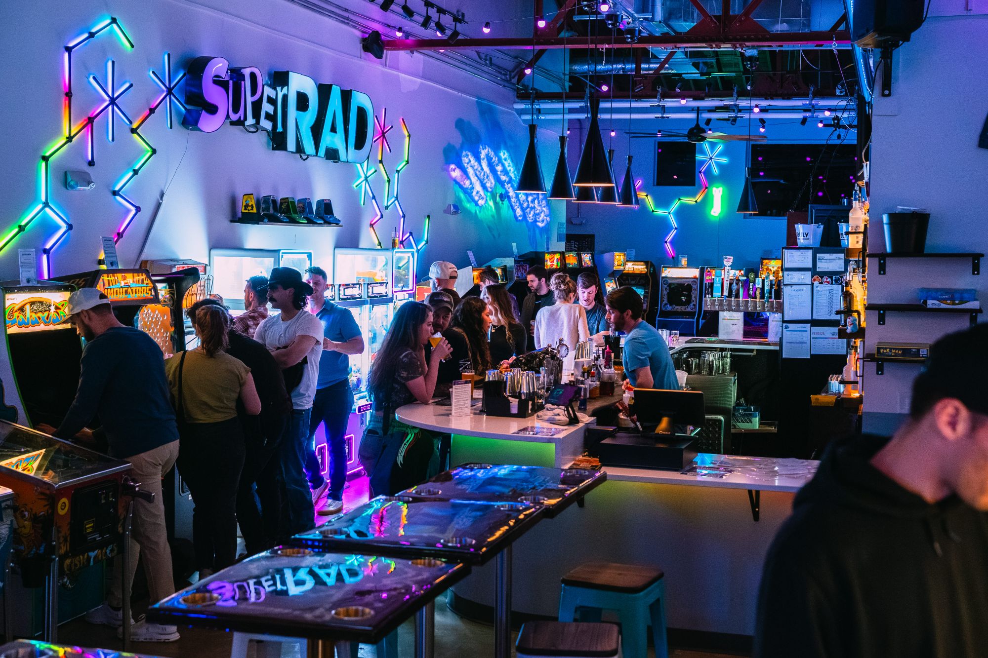 Super Rad neon sign and crowded bar on Glenwood South Raleigh