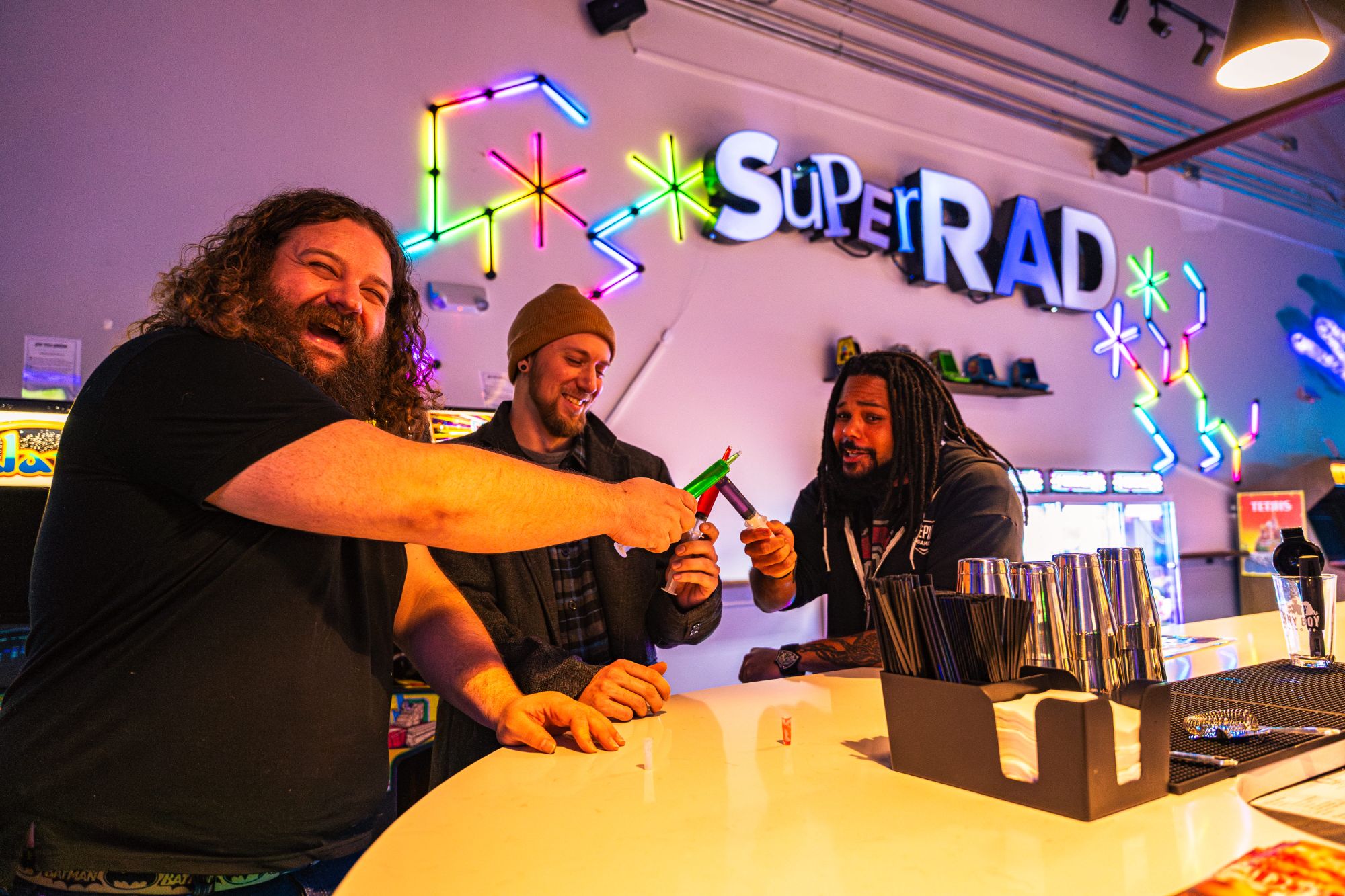 Friends laughing over drinks at a birthday celebration at Super Rad Raleigh