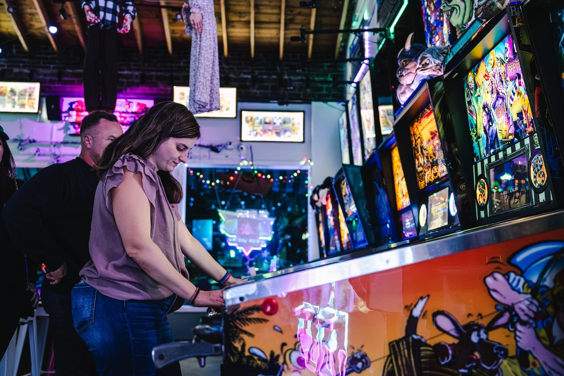Guests playing pinball at Super Rad Raleigh