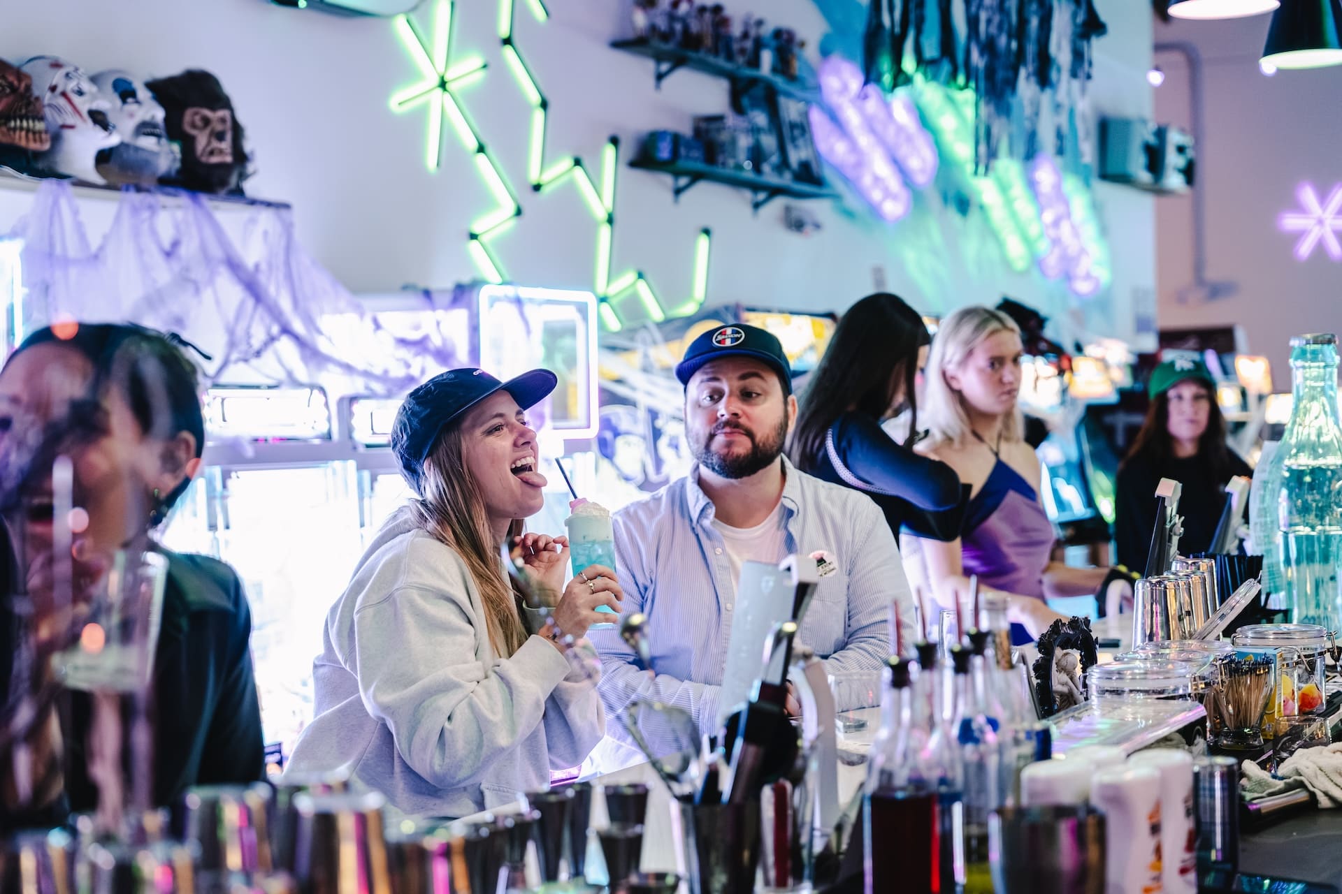 Friends laughing over cocktails at the Super Rad bar in Raleigh