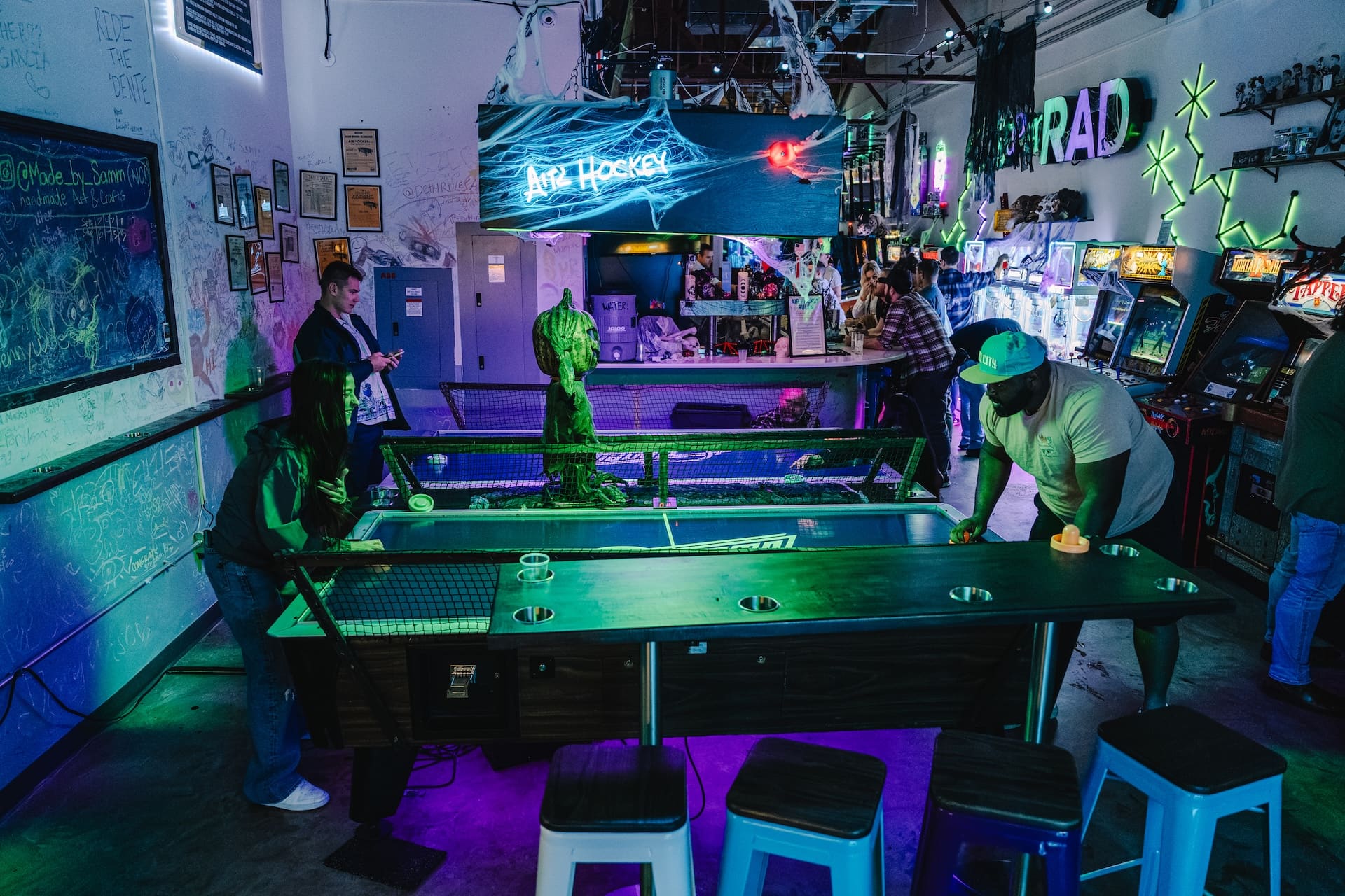 Players facing off at air hockey during an event at Super Rad Raleigh